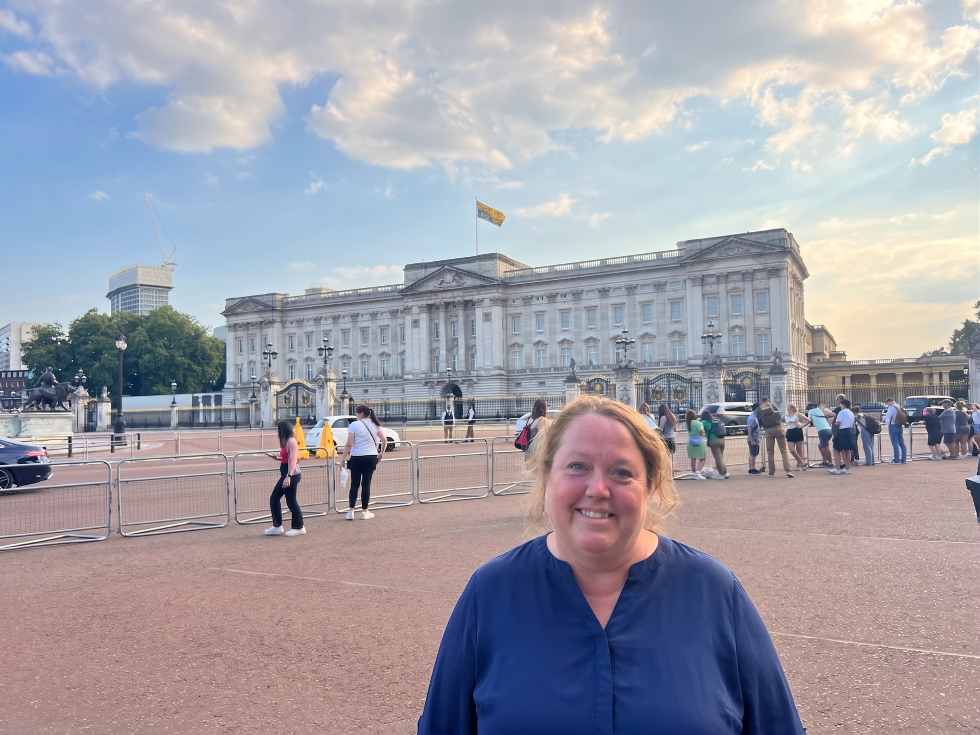 Christine Scheeler in front of Buckingham Palace in warm evening light with the Royal Standard flying