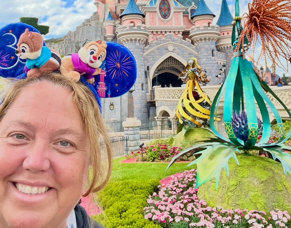 Sleeping Beauty Castle at Disneyland Paris with pink turrets and blue spires against a clear sky