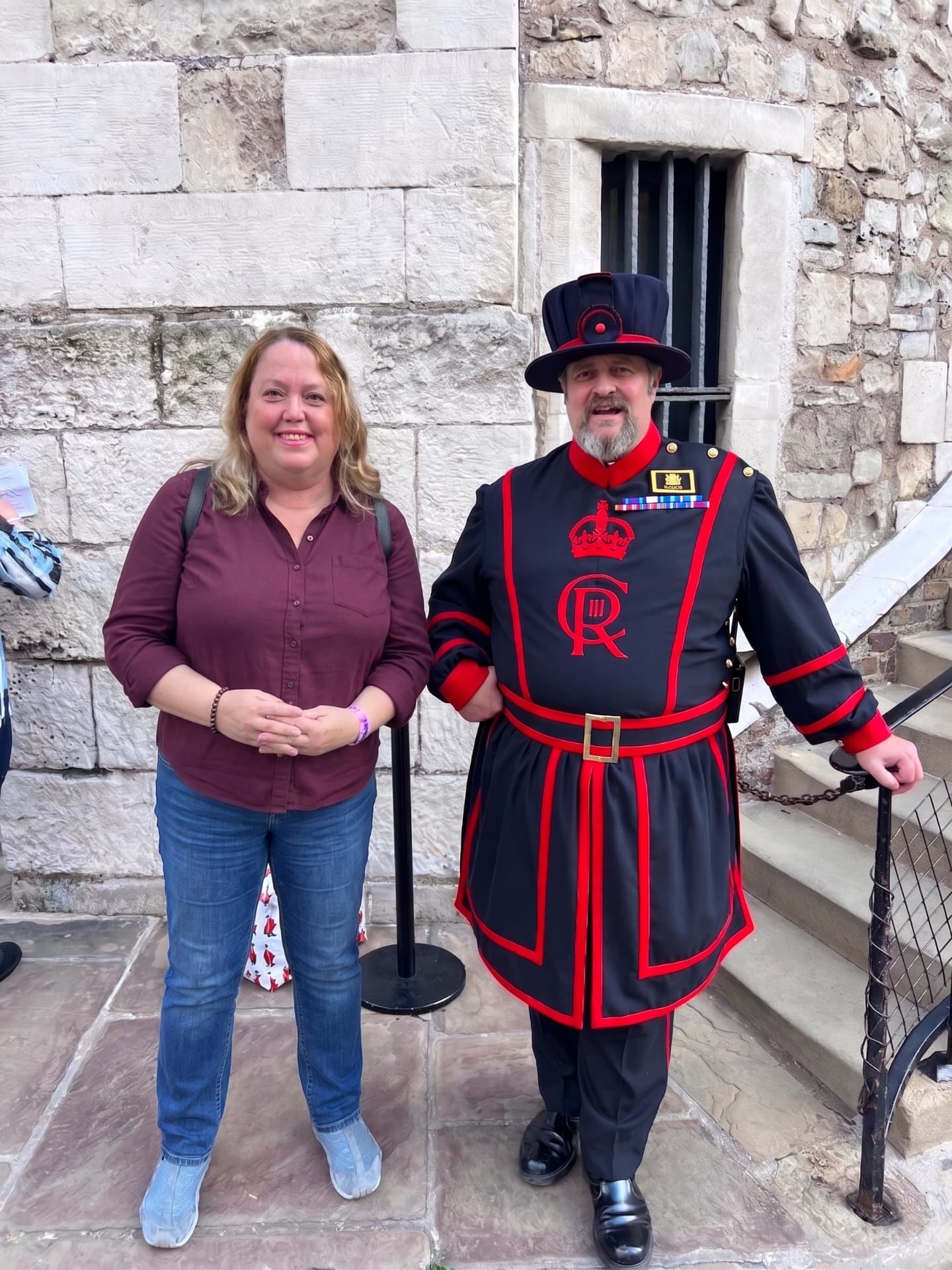 Christine Scheeler standing beside a Yeoman Warder in full uniform inside the Tower of London