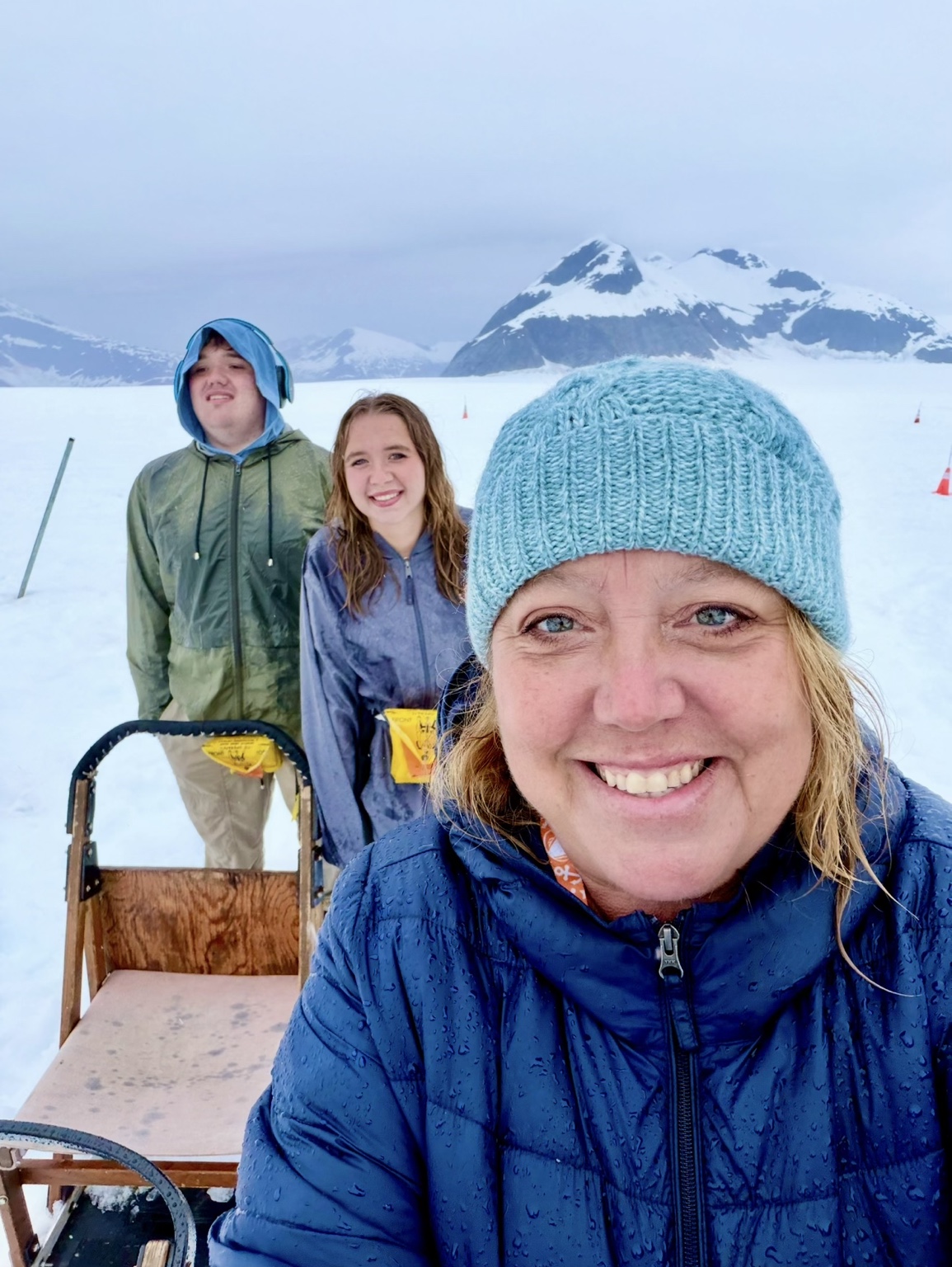 Christine Scheeler with two family members on a snowy glacier with mountains behind them