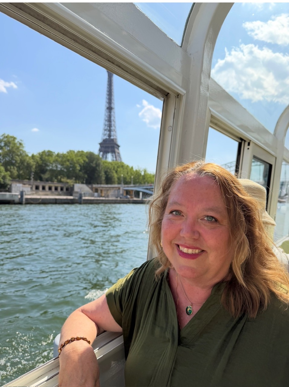 Christine aboard a Seine river boat in Paris with the Eiffel Tower in the background