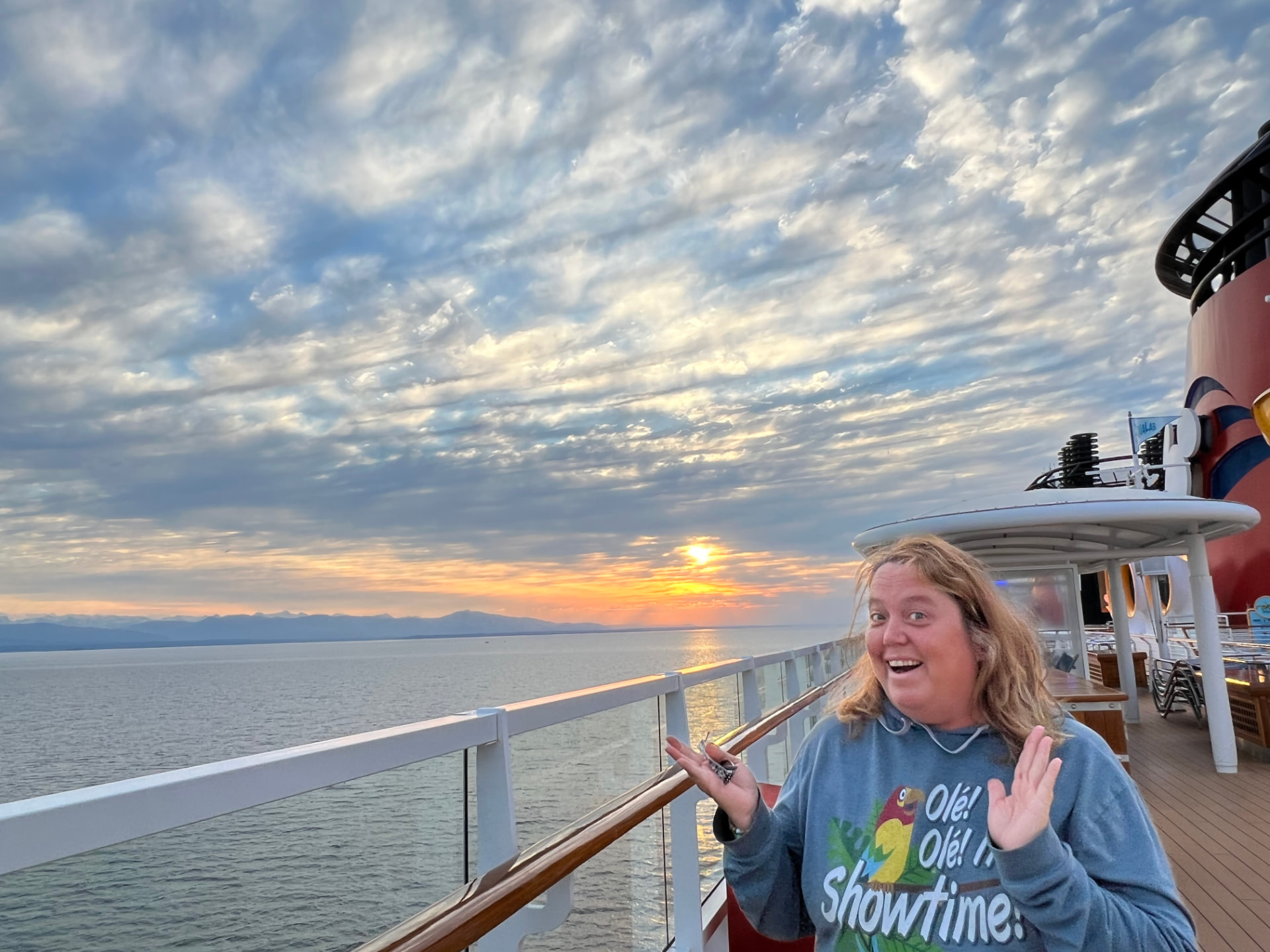 Christine on a Disney Cruise Line deck at sunset with the sea and sky behind her
