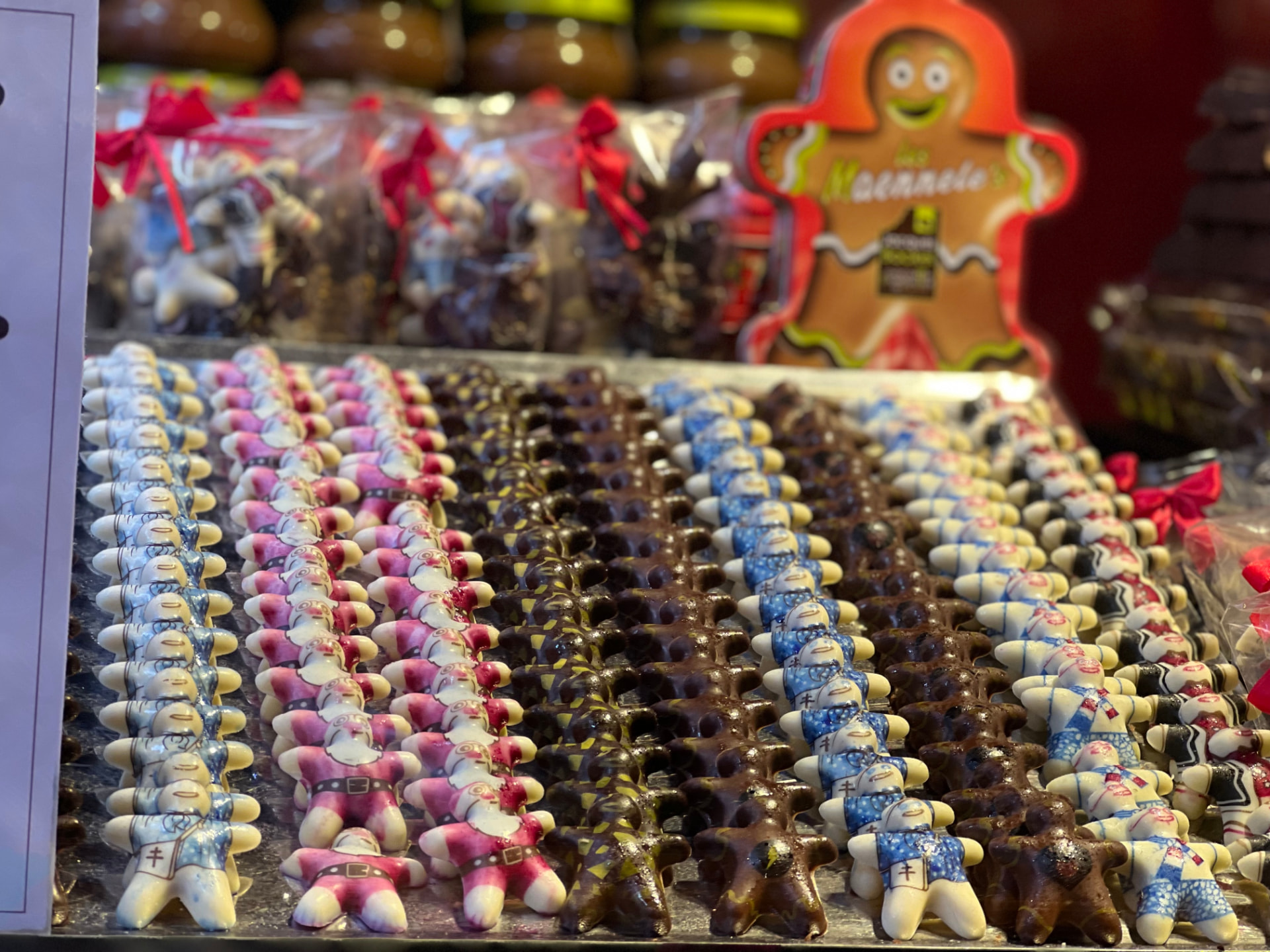 Rows of hand-painted chocolate Santa figures displayed at an Alsatian Christmas market stall