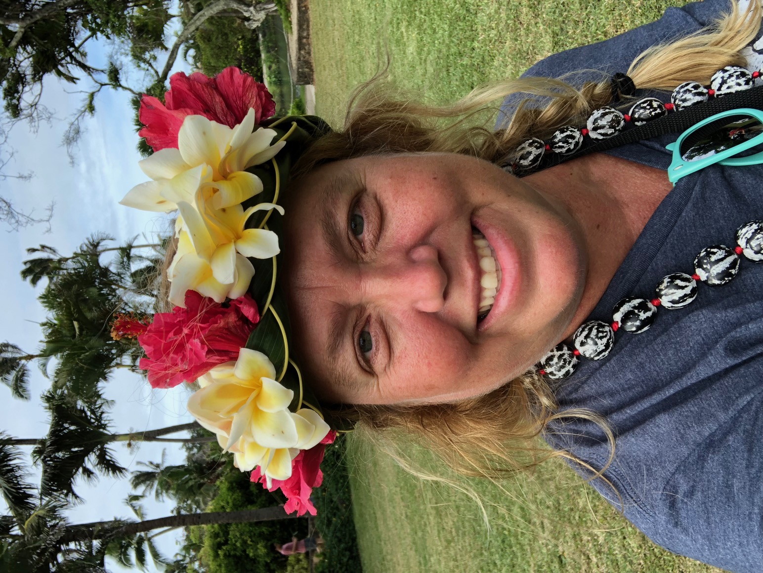 Christine wearing a plumeria and hibiscus flower crown in Hawaii