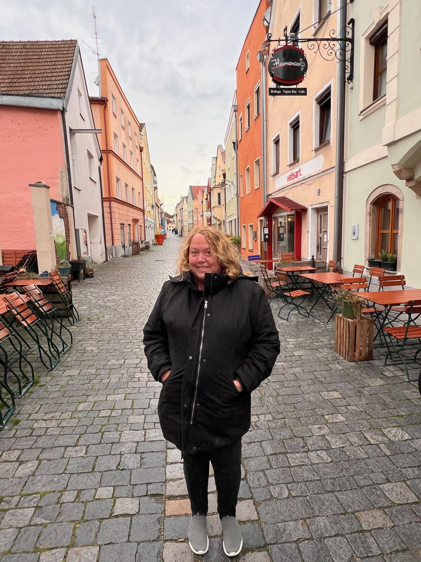 Christine standing on a cobblestone street lined with colorful buildings in Vilshofen, Germany