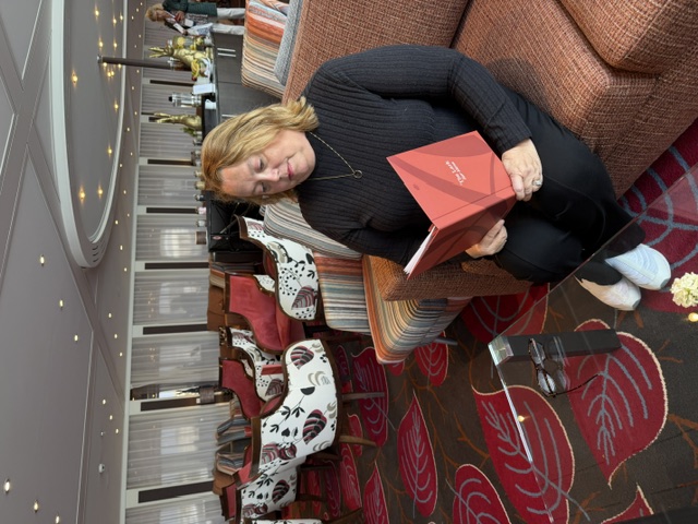 Christine Scheeler reviewing an Adventure the World Travels itinerary aboard a cruise ship
