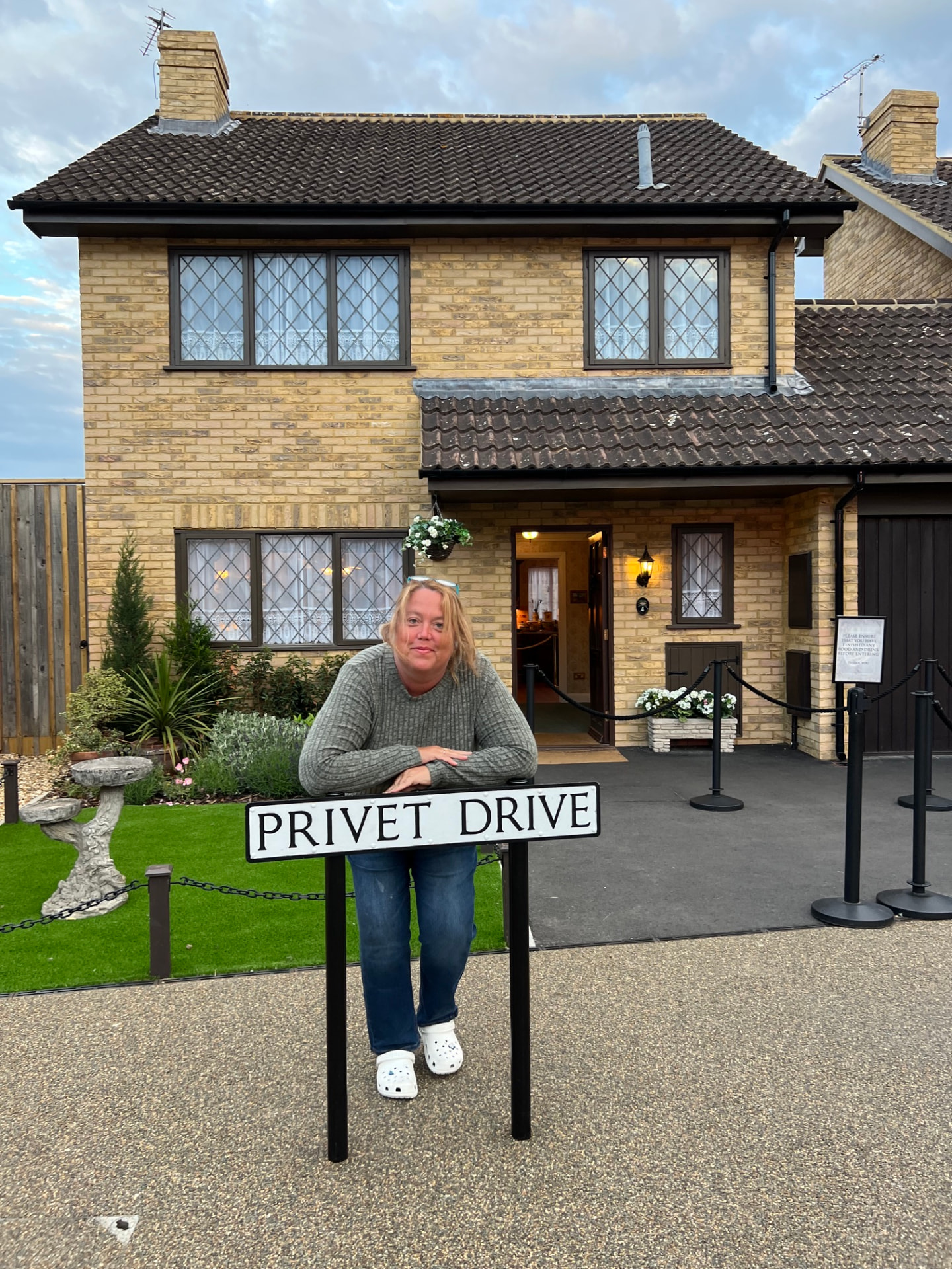 Christine Scheeler leaning on the Privet Drive street sign in front of the Dursley house set